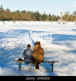 Hoenderloo Niederlande - 13. Februar 2021 - Schlittschuhlauf auf Teich Des Jagdhauses St Hubertus im Nationalpark Hoge Veluwe Stockfoto