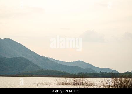 Dramatische Landschaft von Hazy Schichten der Bergketten während Sonnenaufgang mit Wäldern bedeckt. Farbiger Sonnenaufgang in bewaldeten Berghängen mit Nebel Stockfoto