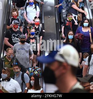 Orlando, Usa. Mai 2021. Passagiere mit Gesichtsmasken als vorbeugende Maßnahme gegen die Ausbreitung von Covid-19 werden auf einer Rolltreppe am Orlando International Airport gesehen. Am 30. April 2021 hat die Transportation Security Administration das Bundesmaskenmandat, das am 11. Mai auslaufen sollte, für alle Fluggäste über 2 Jahren bis zum 13. September verlängert. Kredit: SOPA Images Limited/Alamy Live Nachrichten Stockfoto