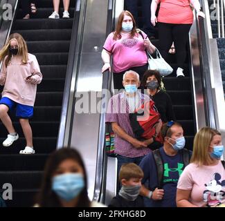 Orlando, Usa. Mai 2021. Passagiere mit Gesichtsmasken als vorbeugende Maßnahme gegen die Ausbreitung von Covid-19 werden auf einer Rolltreppe am Orlando International Airport gesehen. Am 30. April 2021 hat die Transportation Security Administration das Bundesmaskenmandat, das am 11. Mai auslaufen sollte, für alle Fluggäste über 2 Jahren bis zum 13. September verlängert. Kredit: SOPA Images Limited/Alamy Live Nachrichten Stockfoto