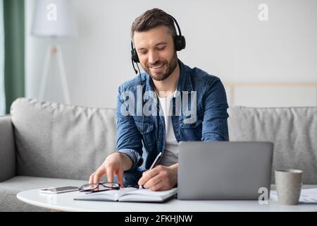 Positiver Mann mittleren Alters, der von zu Hause aus an Online-Schulungen teilnimmt Stockfoto