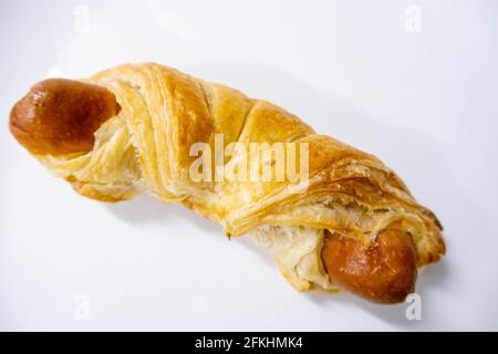 Ein Blätterteig mit Wurst auf Weiß Stockfoto