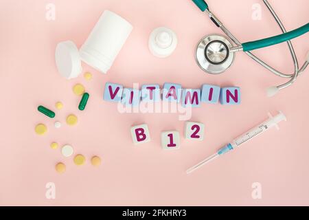 Würfel mit dem Text Medizinisches Zubehör auf dem Tisch mit Tabletten und einer Spritze. Medizinisches Konzept. Stockfoto