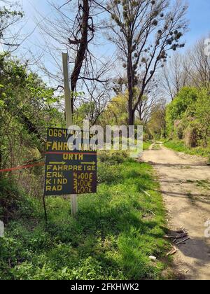 Haslau, Österreich - 24. April 2021: Wanderweg durch die Feuchtgebiete und Wegweiser zur Passagierfähre über die Donau zum Dorf Orth an de Stockfoto