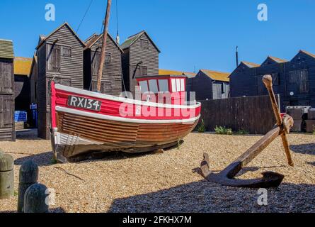 Staycation Idee. Altes Fischerboot aus Holz wurde am Stade, Hastings, East Sussex, mit Net Shops im Hintergrund, befahren. England, Großbritannien Stockfoto