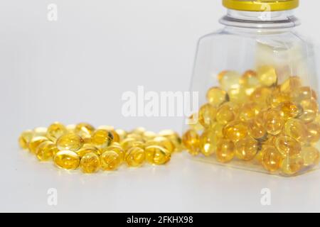 Kabeljau Leberöl Kapseln Flasche mit Kabeljau Leberkapseln mit Einige Kapseln draußen gehalten Stockfoto