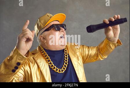 Studioportrait eines glücklichen molligen älteren Mannes mit Mikrofon-Rapping Und Spaß haben Stockfoto