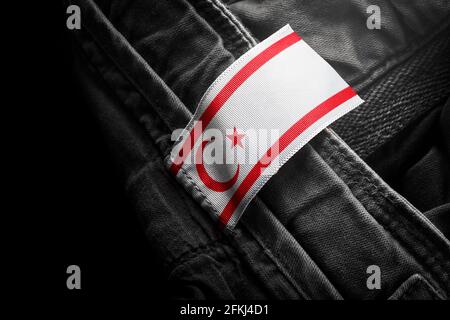 Anhänger auf dunkler Kleidung in Form der Flagge Nordzypern Stockfoto