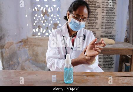 Eine indische Ärztin im medizinischen Bereich, die desinfiziert Hände in der Schule während Covid-19 Stockfoto