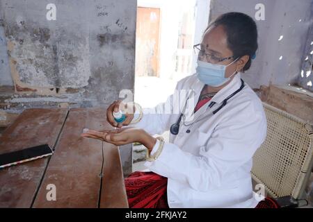 Eine indische Ärztin im medizinischen Bereich, die desinfiziert Hände in der Schule während Covid-19 Stockfoto