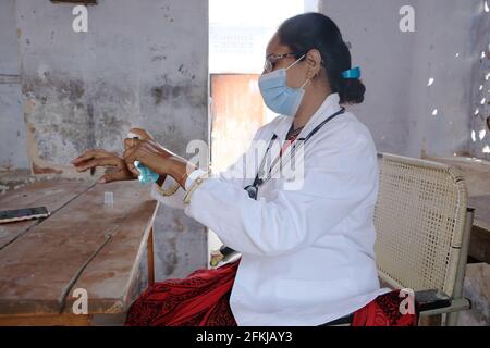 Eine indische Ärztin im medizinischen Bereich, die desinfiziert Hände in der Schule während Covid-19 Stockfoto