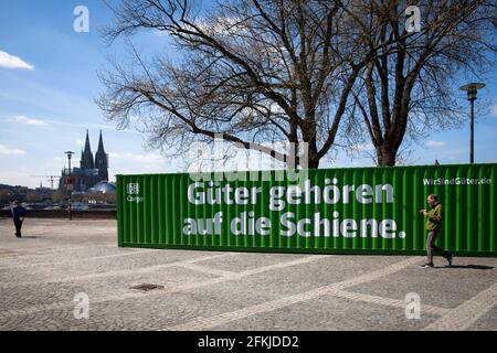 Mit einem grünen Frachtcontainer am Rheinufer in Deutz macht DB Cargo auf das Potenzial der CO2-Reduktion durch den Transport durch rai aufmerksam Stockfoto