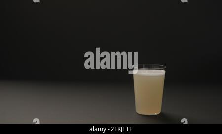Zitronenlimonade aus Ingwer in Glas auf schwarzem Papierhintergrund mit Kopierfläche, breites Foto Stockfoto