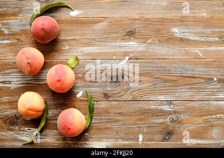 Ein Haufen reifer organischer Pfirsiche im Stapel auf einem Tisch mit braunem, gerongenem Holz. Lokale Produkte ernten Haufen auf vintage Holzarbeitspppich. Clean Eating Konz Stockfoto