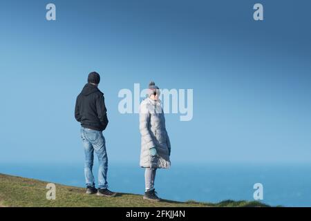 Zwei Menschen stehen auf Towan Head und genießen die Aussicht in Newquay in Cornwall. Stockfoto