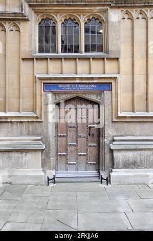 Blick auf die fassade im englischen gotischen Stil mit einer alten Holztür im Innenhof der Old Bodleian Library, Oxford, Großbritannien. Stockfoto