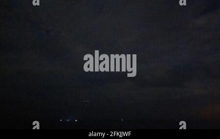 Die Raumsonde SpaceX Crew Dragon Resilience wird in der Ferne gesehen, als sie mit den NASA-Astronauten Mike Hopkins, Shannon Walker und Victor Glover und dem Astronauten der Japan Aerospace Exploration Agency (JAXA), Soichi Noguchi, an Bord im Golf von Mexiko vor der Küste von Panama City, Florida, am Sonntag, den 2. Mai 2021, landet. Die NASA-Mission SpaceX Crew-1 war der erste Rundflug der Raumsonde SpaceX Crew Dragon und der Falcon 9-Rakete mit Astronauten zur Internationalen Raumstation im Rahmen des Commercial Crew Program der Agentur. Hinweis: Dieses Bildrauschen ist das Ergebnis der Verwendung einer sehr hohen Empfindlichkeit Stockfoto