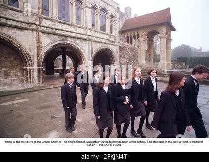 Chapel Chor Mitglieder der Kings School Canterbury in der gedenkhof der Schule die Treppe im Hintergrund Ist mittelalterlich Stockfoto