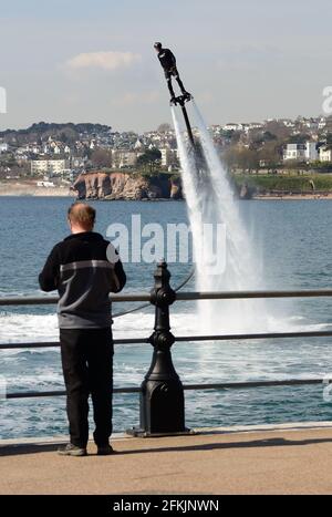 Fly-Boarder in Aktion an der Strandpromenade von Torquay in Devon. Stockfoto