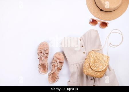 Frauenkleidung und Accessoires: Beigefarbenes trägerloses Kleid, Hipster-Chic-Stil Boho-Aluminiumohrringe, lässige Sandalen mit Seil, braune Sonnenbrillen, Stylis Stockfoto