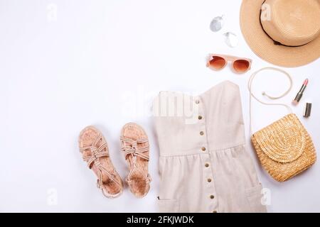 Frauenkleidung und Accessoires: Beigefarbenes trägerloses Kleid, Hipster-Chic-Stil Boho-Aluminiumohrringe, lässige Sandalen mit Seil, braune Sonnenbrillen, Stylis Stockfoto