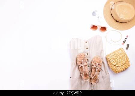 Frauenkleidung und Accessoires: Beigefarbenes trägerloses Kleid, Hipster-Chic-Stil Boho-Aluminiumohrringe, lässige Sandalen mit Seil, braune Sonnenbrillen, Stylis Stockfoto