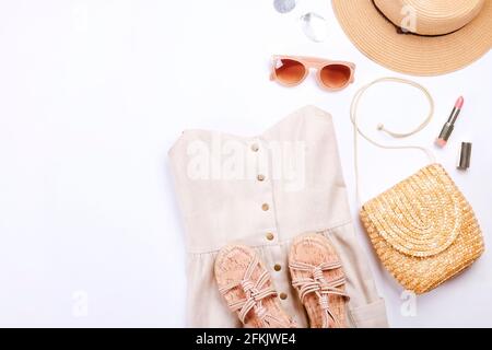 Frauenkleidung und Accessoires: Beigefarbenes trägerloses Kleid, Hipster-Chic-Stil Boho-Aluminiumohrringe, lässige Sandalen mit Seil, braune Sonnenbrillen, Stylis Stockfoto