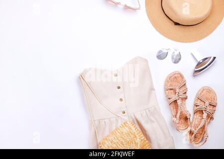 Frauenkleidung und Accessoires: Beigefarbenes trägerloses Kleid, Hipster-Chic-Stil Boho-Aluminiumohrringe, lässige Sandalen mit Seil, braune Sonnenbrillen, Stylis Stockfoto