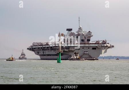 Portsmouth, England, Großbritannien. 2021. HMS Queen Elizabeth ein Flugzeugträger mit begleiteten Schleppern verlässt Portsmouth Harbour in Richtung des offenen Meeres. Stockfoto