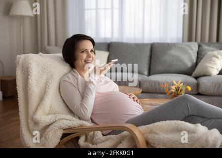 Glückliche Schwangeren nehmen Audio auf Handy auf Stockfoto