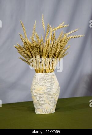 Ein Strauß Weizenspitzen in einer Papiervase. Handgemachtes Stillleben. Stockfoto