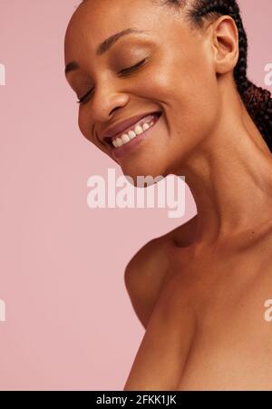 Porträt einer lächelnden afrikanerin mit gesunder Haut. afroamerikanische Frau lächelt mit geschlossenen Augen. Stockfoto