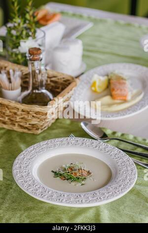 Käsesuppe mit Lachs im grünen Hintergrund Stockfoto