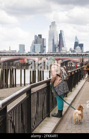 Eine junge Frau und ihr Hund aus Pommern in der Nähe der Blackfriars Bridge, Gabriel's Wharf, Southbank, Lambeth, London, SE1, GROSSBRITANNIEN Stockfoto