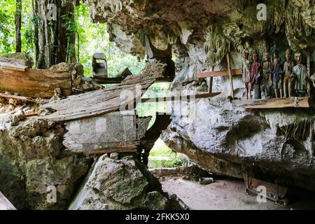 Verfaulte Särge, Hüter der Toten (Tau-Tau’s) und menschliche Schädel in der Tampang Allo Burial Cave, Toraja, Sulawesi, Indonesien Stockfoto