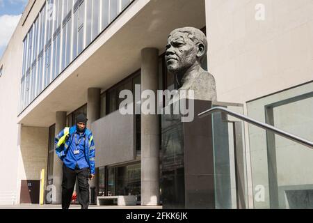 Vor der Royal Festival Hall, London, England, Großbritannien, führt ein Sicherheitsbeamter die Statue von Ian Walters des ehemaligen südafrikanischen Präsidenten Nelson Mandela Stockfoto