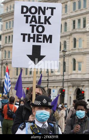 London, Großbritannien. Mai 2021. Ein Mann hält ein Plakat mit der Aufschrift Rede nicht mit ihnen hinter einem Beamten des Metropolitan Police Liaison Teams (PLT) auf einer Kill the Bill Demonstration auf dem Trafalgar Square als Teil eines Nationalen Aktionstages, der mit dem Internationalen Arbeitertag zusammenfällt. Landesweite Proteste wurden gegen das Gesetz 2021 von Polizei, Kriminalität, Verurteilung und Gerichten organisiert, das der Polizei eine Reihe neuer Ermessensbefugnisse zur Schließung von Protesten gewähren würde. Kredit: Mark Kerrison/Alamy Live Nachrichten Stockfoto