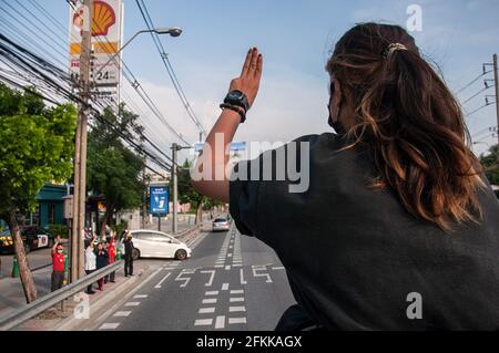 Bangkok, Thailand. Mai 2021. Ein Protestler grüßt während der Demonstration mit drei Fingern. Die von der REDEM-Gruppe angeführten prodemokratischen Demonstranten versammeln sich am Victory Monument, bevor sie mit dem Fahrzeug zum Strafgerichtshof von Thailand fahren, um die Freilassung von inhaftierten pro-demokratischen Aktivisten zu fordern, die nach dem landesgroßen Gesetz (Artikel 112 des thailändischen Strafgesetzbuches) festgenommen wurden. (Foto von Peerapon Boonyakiat/SOPA Image/Sipa USA) Quelle: SIPA USA/Alamy Live News Stockfoto