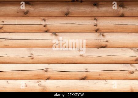 Holzwand aus unfarbigen Baumstämmen, frontale Hintergrund Foto-Textur Stockfoto