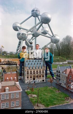 Drei junge Jungen posieren einige Monate nach der Einweihung des Mini-Europe am 1990. April im Hintergrund das Atomium, Brüssel, Belgien Stockfoto