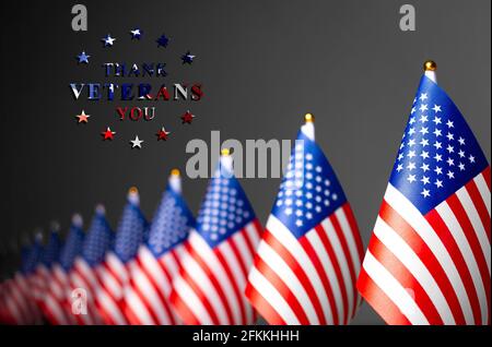 US-Flaggen und die Inschrift danken euch Veteranen. Konzept zum Memorial Day. Foto auf grauem Hintergrund. Stockfoto