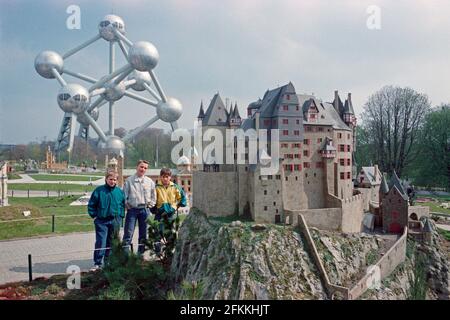 Drei junge Jungen posieren im Mini-Europe, Schloss Eltz, wenige Monate nach seiner Einweihung, am 1990. April, im Hintergrund das Atomium, Brüssel, Belgien Stockfoto