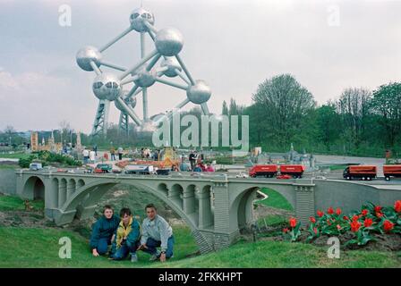 Drei junge Jungen posieren auf Mini-Europe unter einer Autobahnbrücke, wenige Monate nach der Einweihung, am 1990. April, im Hintergrund das Atomium, Brüssel, Belgien Stockfoto