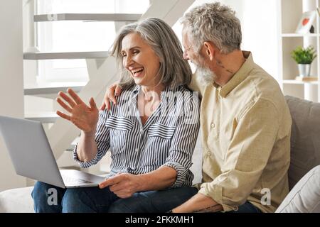 Glücklich reifes altes Paar winkt mit virtuellen Treffen auf Laptop zu Hause. Stockfoto