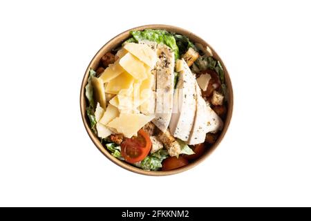 Caesar Salat isoliert. Köstlicher frischer Hähnchensalat in einem runden braunen Lebensmittelbehälter. Stockfoto