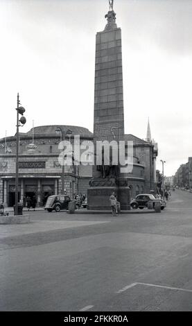 1950er Jahre, historische Ansicht aus dieser Zeit, der Gedenkstatue des irischen Nationalisten Charles Stewart Parnell in der Mitte der O'Connell Street Upper, North City, Dublin, Irland, neben dem Ambassador Cinema. Das Denkmal für Parnell, einen Verfechter der Home Rule, wurde im Oktober 1911 enthüllt. Stockfoto