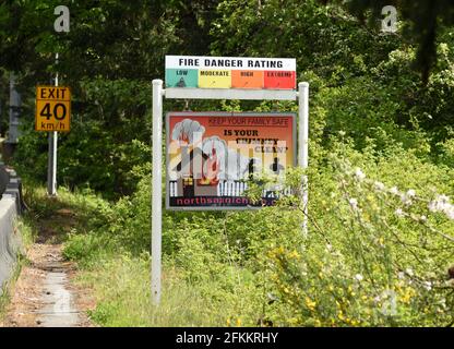 Ein Schild zeigt eine niedrige Brandgefahrentemperatur und ein weiteres an Warnt vor den Gefahren eines Schornsteins, der gereinigt werden muss Könnte einen Hausbrand verursachen Stockfoto