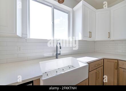 Eine moderne Küche mit Holzmöbeln und großen Fenstern Stockfoto