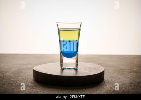 Selbstgemachter gelber und blauer transparenter Alkoholdrink in Glas Limoncello und curacao, Nahaufnahme Konzeptfarbe der ukrainischen Flagge Stockfoto