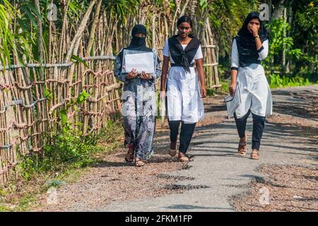 BAGERHAT, BANGLADESCH - 16. NOVEMBER 2016: Muslimische Schulmädchen gehen in Bagerhat, Bangladesch, auf einer Straße Stockfoto